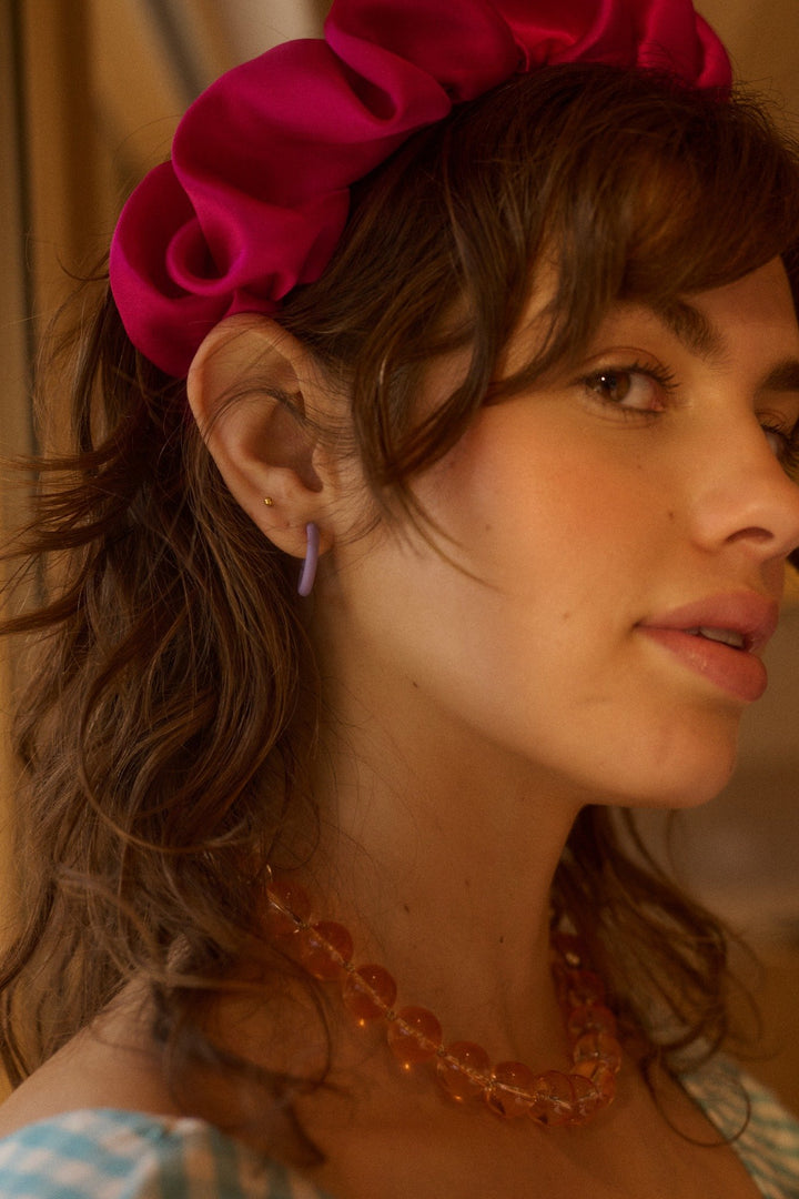 Model met lila harsen oorringen, ideaal voor een speelse look