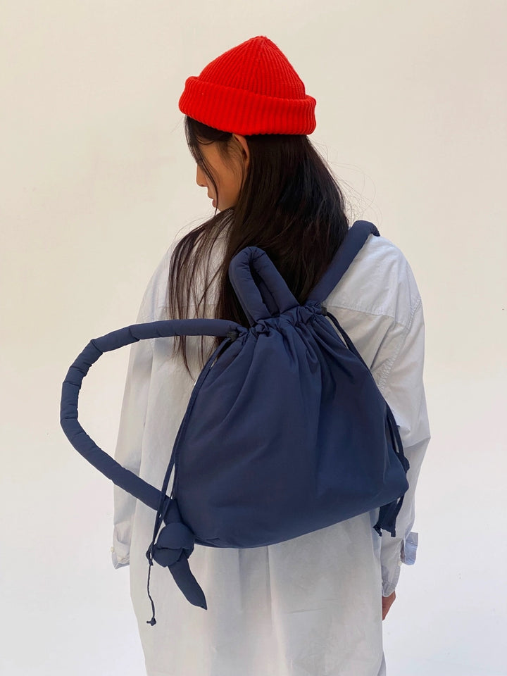 Model draagt de Olend Ona Soft Bag in donkerblauw als rugzak over één schouder