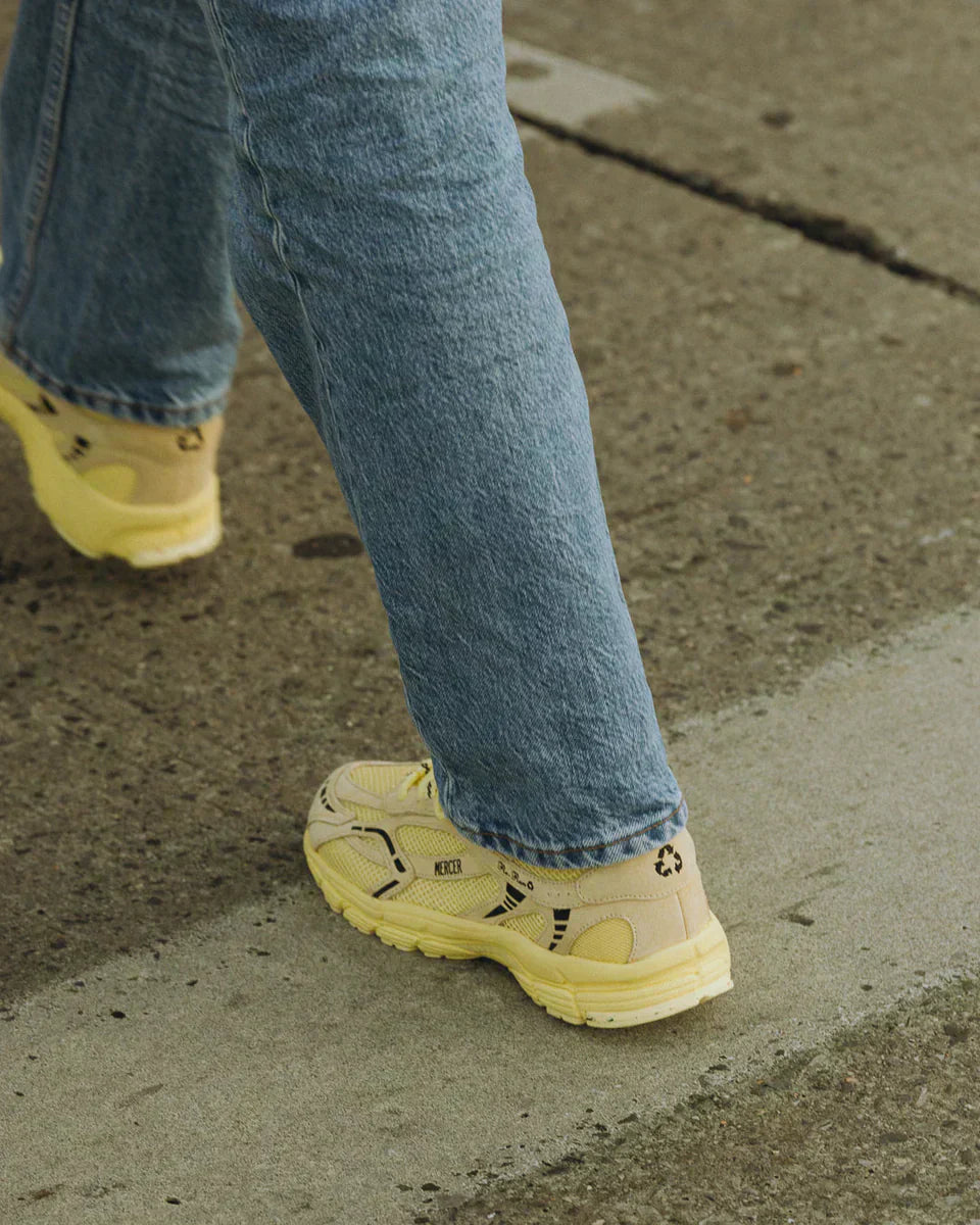 Mercier Re-Run sneaker in monochroom geel, gedragen met jeans op straat bij Anna Pops