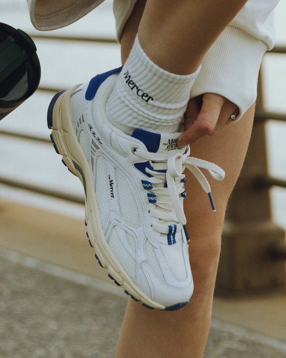 Mercer Re-Run Vintage wit blauw sneaker gedragen door tiener, close-up met zicht op retro details en blauwe accenten
