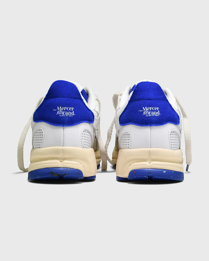 Achteraanzicht van Mercer Re-Run Vintage sneakers in wit en blauw met retro zool en merklogo op hiel