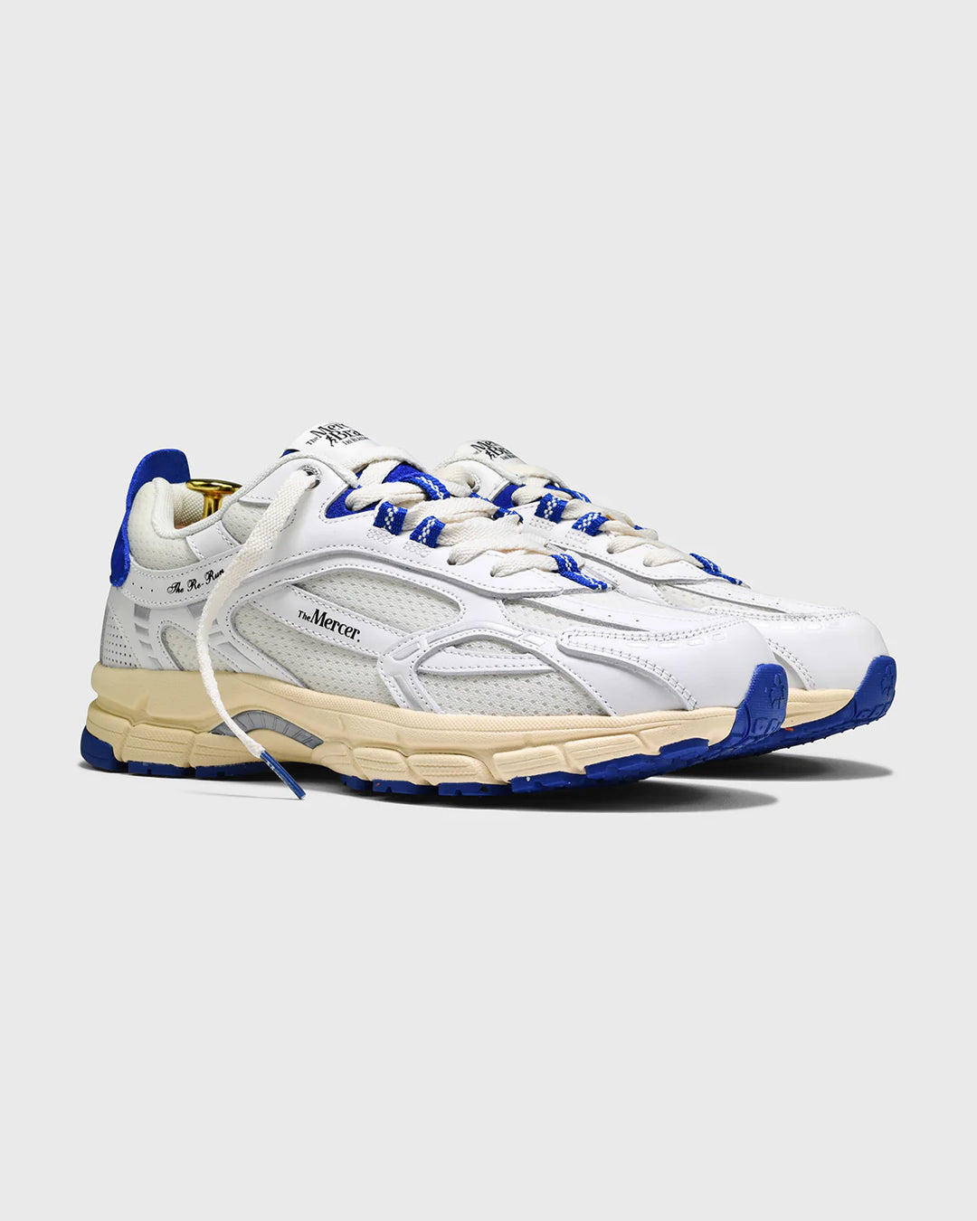 Witte Mercer Re-Run Vintage sneakers met blauwe details, retro design en sportieve uitstraling, zijaanzicht op grijze achtergrond