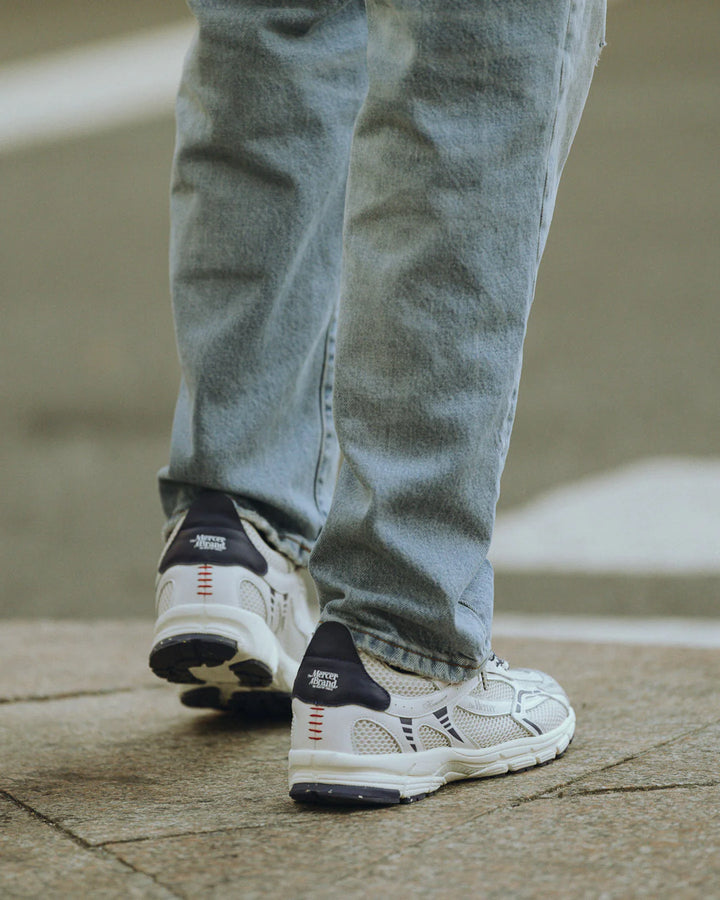 Mercer Re-Run sneaker wit blauw gedragen op straat door tiener of volwassene met jeans