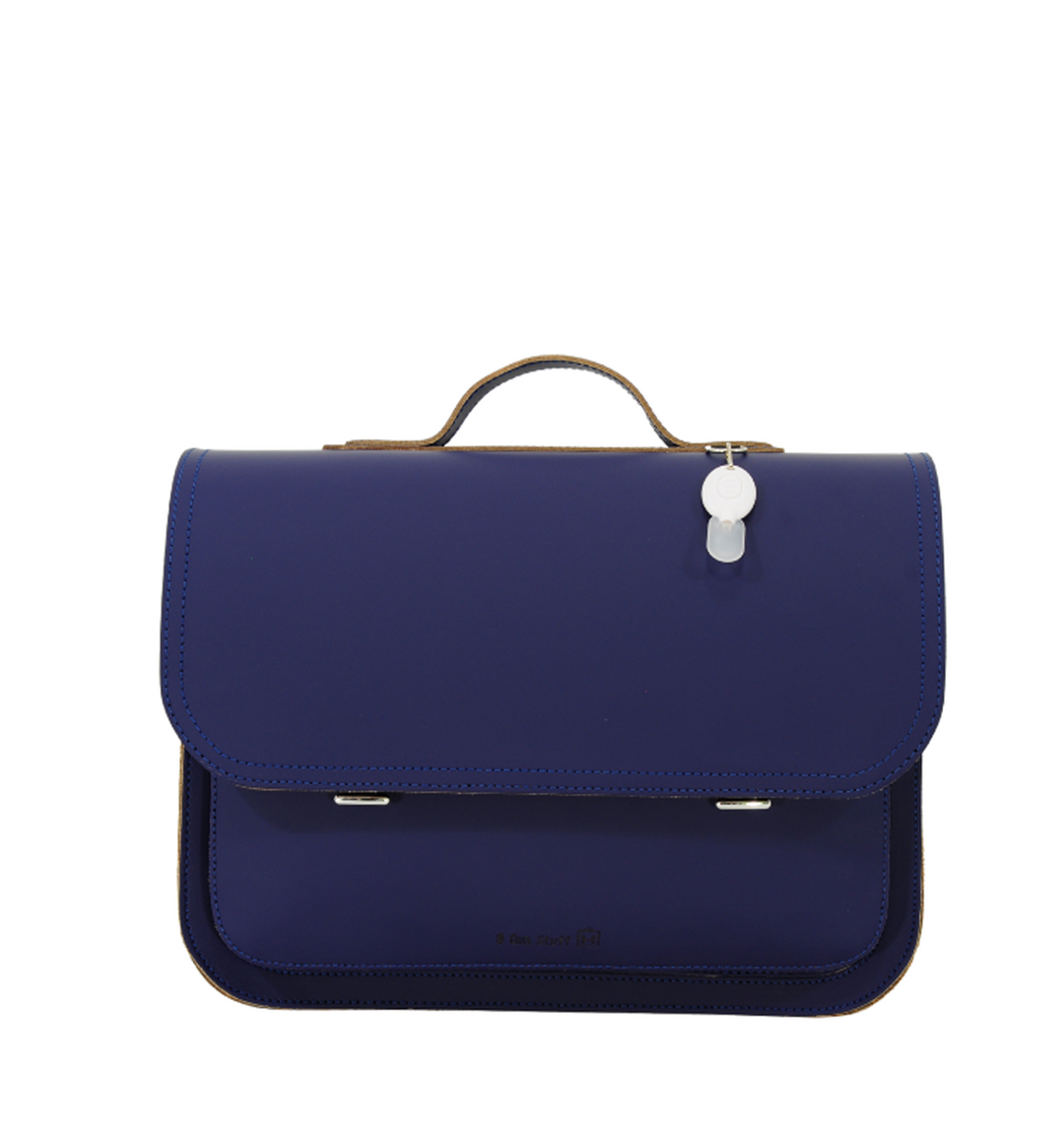 Marineblauwe kinderrugzak met afgeronde flap, lederen handvat en witte labelhanger aan de bovenkant.