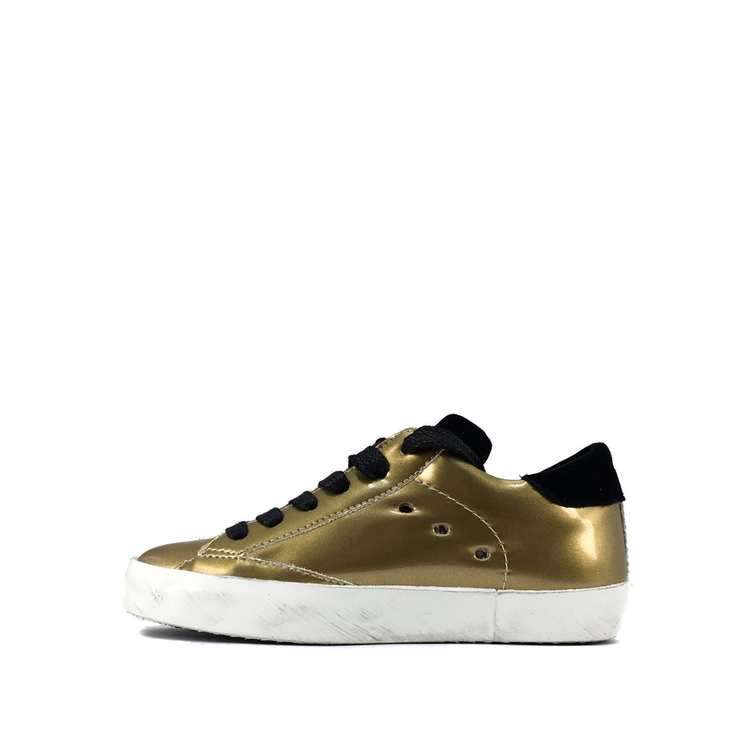 Lage gouden sneaker met zwarte accenten