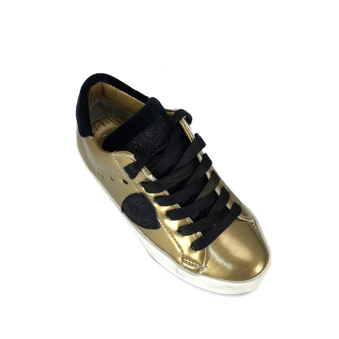 Lage gouden sneaker met zwarte accenten